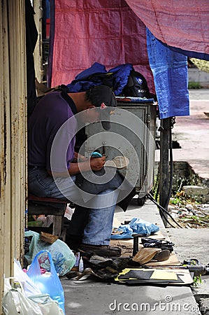 Shoe repairer at Siti Khadijah Market in in Kota Bharu, Kelantan, Malaysia, Asia Editorial Stock Photo